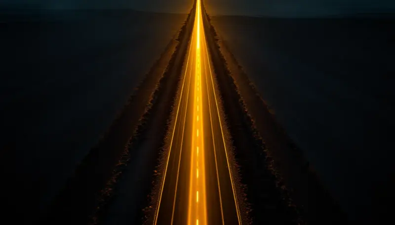 One glowing road breaks sharply away from two others at a dramatic fork in dark landscape
